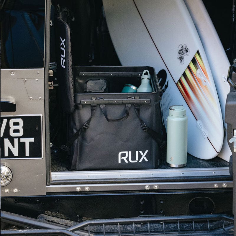 RUX in a truck with a surfboard